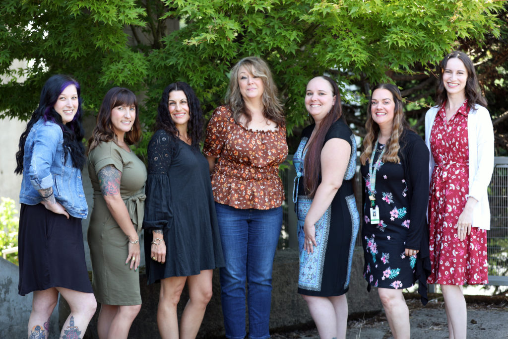 admin assistants in front of tree